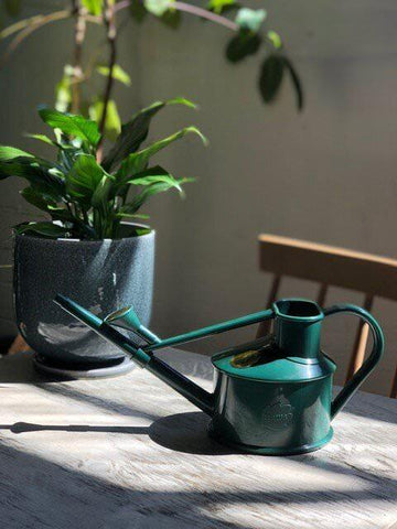 haws green watering can on the table